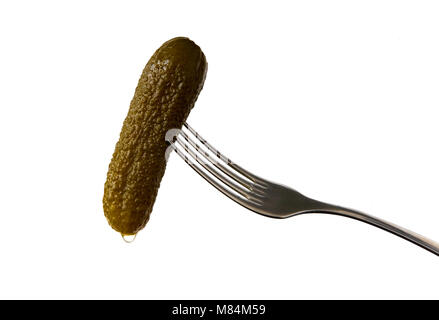 Salted cucumber with a drop of brine on the fork. Isolated object. Stock Photo