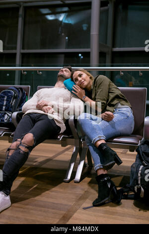 Couple sleeping in waiting area Stock Photo