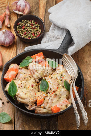 Rabbit stewed with vegetables and herbs in a cast iron skillet. Meat, carrots, shallots, garlic, and Basil. Seasonings. Dinner in a rustic style. Sele Stock Photo