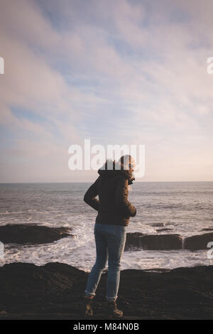 Cool woman standing on the beach with arms crossed Stock Photo - Alamy