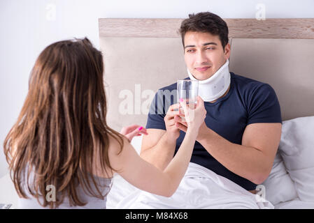 Loving wife taking care of injured husband in bed Stock Photo