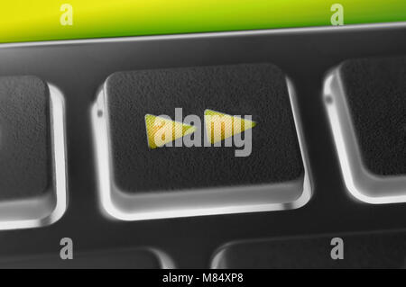 Close Up Of A Black Fast Forward Button Of A Black Remote Control With Backlight Stock Photo