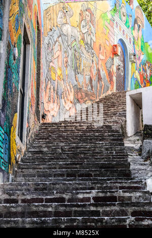 Colorful mural painting on a wall next to narrow winding steps at Guanajuato, Mexico Stock Photo