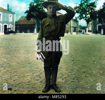 Colorized portrait of a young boy in uniform saluting, 1918. He appears to be wearing a Boy Scout uniform. (Photo by Burton Holmes) Stock Photo