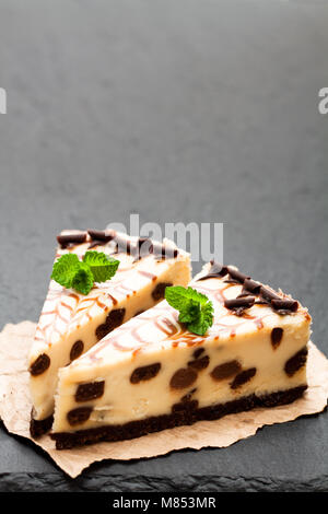 Baked  white and dark chocolate cheese cake on black stone background Stock Photo