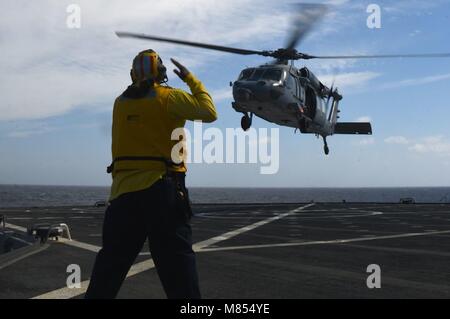 180313-N-QR145-293 MEDITERRANEAN SEA (March 13, 2018)  Dan Thomas, a Military Sealift Command civil service mariner, signals to an MH-60S Sea Hawk helicopter, assigned to the 'Ghost Riders' of Helicopter Sea Combat Squadron (HSC) 28, aboard the Blue Ridge-class command and control ship USS Mount Whitney (LCC 20) while conducting a replenishment-at-sea with fleet replenishment oiler USNS Patuxent (T-AO 201) March 13, 2018. Mount Whitney, forward-deployed to Gaeta, Italy, operates with a combined crew of U.S. Navy Sailors and Military Sealift Command civil service mariners. (U.S. Navy photo by M Stock Photo