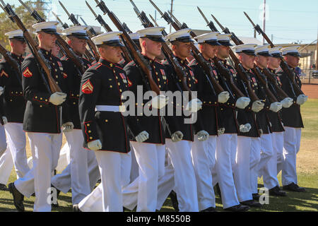 The U.S. Marine Corps Silent Drill Platoon marches during the “pass in review” for a dress rehearsal of the Battle Color ceremony at Marine Corps Air Station Yuma, Yuma, Az., March 2, 2018. This dress rehearsal marks the end of the Marines’ month-long training phase in Yuma. The Marines will move on to display their hard work and dedication during their performances on the West Coast Tour and throughout the 2018 parade season.(Official Marine Corps photo by Cpl. Damon Mclean/Released) Stock Photo