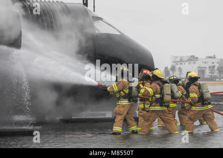 Firefighters with the 374th Civil Engineer Squadron fire and emergency services battle a simulated aircraft fire during a live-fire training at Yokota Air Base, Japan, March 8, 2018. Aircraft live-fire training is conducted periodically throughout the year to ensure Airmen and civilians with the 374th CES and 374th Maintenance Squadron repair and reclamation section are always prepared to combat aircraft fuel fires. (U.S. Air Force photo by Yasuo Osakabe) Stock Photo