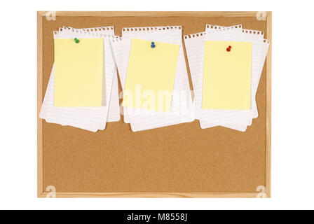 Cork notice or bulletin board with lots of blank sheets of untidy torn notepaper and yellow office sticky notes isolated on a white background. Space  Stock Photo