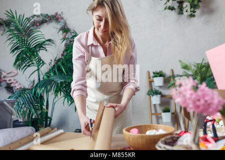 Female florist creating bouquet on the table. Stock Photo