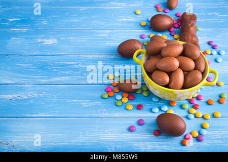 Full bowl of Easter chocolate eggs with color dragee on  a wooden background Stock Photo