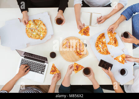 Lunch and people concept. Happy business team eating pizza in office Stock Photo
