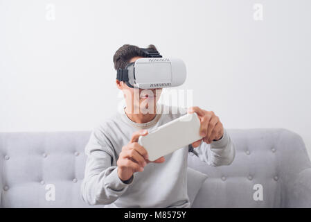 Asian man wearing virtual reality goggles or VR headset Stock Photo