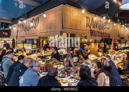 Tourists eating in a tapas bar at Boqueria market, Barcelona, Catalonia, Spain Stock Photo