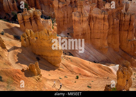 Hikers enjoy the early morning light on hoodoos below the Sunset Point overlook in Bryce Canyon National Park, Utah USA Stock Photo
