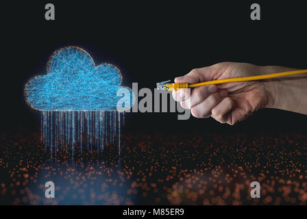 A hand holding an RJ45 cable, guiding up the connection in cloud computing. Stock Photo