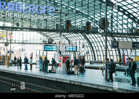 The central station is called Berlin Hauptbahnhof. People are waiting for the train on the platform. Stock Photo