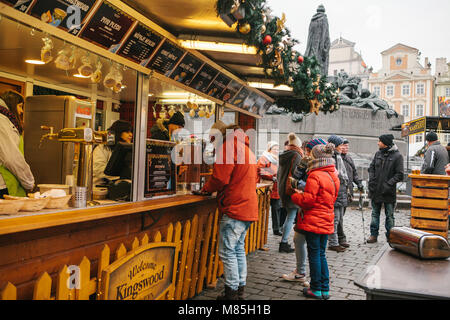 Prague, December 13, 2016: Old Town Square in Prague on Christmas Day. Christmas market in the main square of the city. The man is buying mulled wine. Stock Photo
