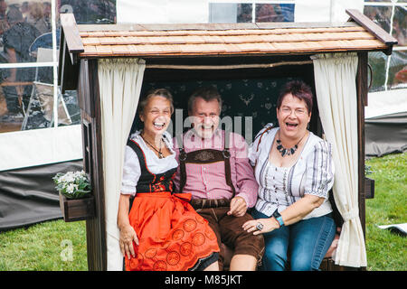Prague, September 23, 2017: Celebrating the traditional German beer festival called Oktoberfest in the Czech Republic. Elderly man and two women laugh Stock Photo