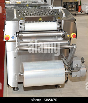 Automated Foil Packaging Machine in Food Factory Stock Photo