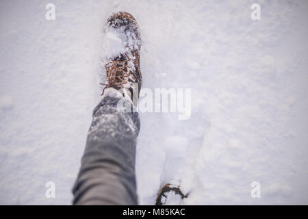 Photo of man's feets in boots in snow Stock Photo