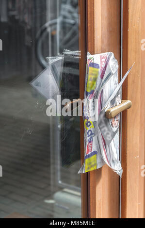 advertising brochures clamped between the door handle of a door Stock Photo