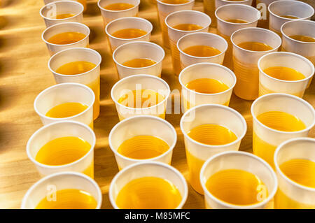 many plastic cups filled with lemonade placed on a table Stock Photo