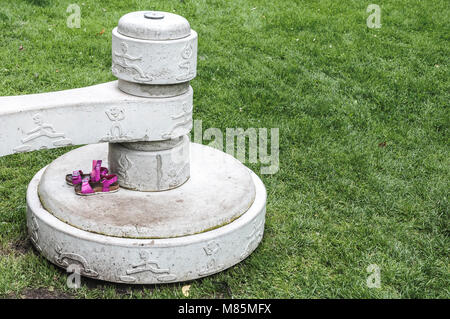 two small children's sandals placed on a concrete block Stock Photo