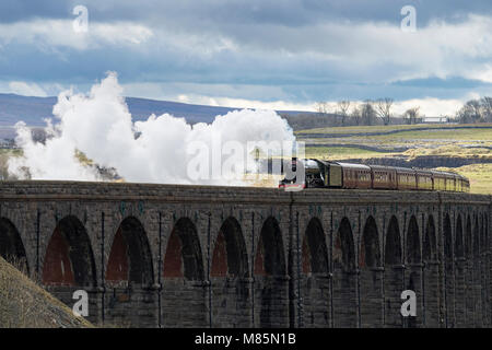 Puffing steam cloud, iconic locomotive LNER class A3 60103 Flying Scotsman, travels over arches of Ribblehead Viaduct - North Yorkshire, England, UK.