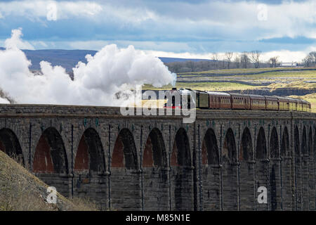 Puffing steam cloud, iconic locomotive LNER class A3 60103 Flying Scotsman, travels over arches of Ribblehead Viaduct - North Yorkshire, England, UK. Stock Photo