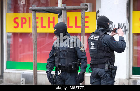 14 March 2018, Germany, Leipzig: SWAT police officers stand infront of a shop on Leipzig's Eisenbahnstrasse during a large scale police operation against drug-related and gun-enabled crime. Photo: Sebastian Willnow/dpa-Zentralbild/dpa Stock Photo