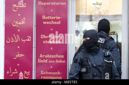 14 March 2018, Germany, Leipzig: SWAT police officers stand in front of a shop on Leipzig's Eisenbahnstrasse during a large scale police operation against drug-related and gun-enabled crime. Photo: Sebastian Willnow/dpa-Zentralbild/dpa Stock Photo