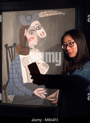 Hong Kong, Hong Kong SAR, CHINA. 15th Mar, 2018. Sotheby's Hong Kong celebrates Hong Kong Arts month with ''Face-off: Picasso/Condo'', exhibition of collectors works along with Sotheby's sale items. A woman poses for a selfie with Pablo Picasso's ''Femme dans un fauteuil Credit: Jayne Russell/ZUMA Wire/Alamy Live News Stock Photo