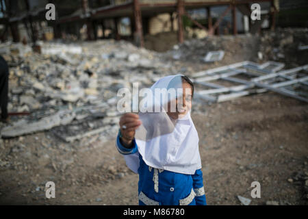 (180315) -- SARPOL-E ZAHAB, March 15, 2018 (Xinhua) -- Paria plays amidst the debris of buildings in Sarpol-e Zahab city, western Iran, on March 11, 2018. Paria, 10-year-old Iranian-Kurdish girl, lost her father during a 7.3-magnitude earthquake on Nov. 12, 2017. Now, she is living with her mother and only brother in a conex home, as their house was completely destroyed during the tremor. She has had her father as the 'hero' of her life, she sobbed. Asked what her top dream in her life is, she dropped her head saying in low voice: 'I cannot think of another disaster like 'this' for anybody in  Stock Photo