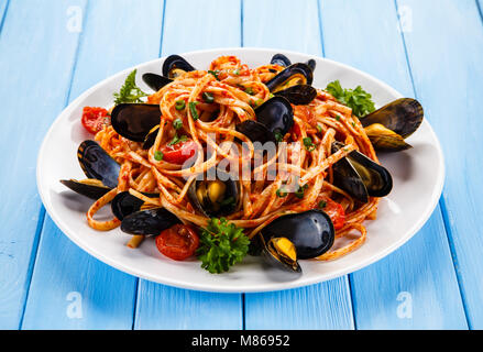 Cooked mussels and pasta on wooden table Stock Photo