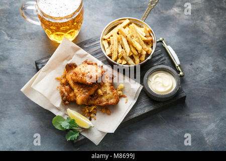 Fish and chips with mayo on crumpled paper. Stock Photo
