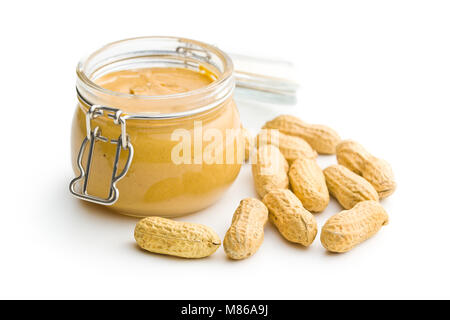 Peanut butter in jar and peanuts isolated on white background. Stock Photo