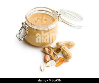 Peanut butter in jar and peanuts isolated on white background. Stock Photo