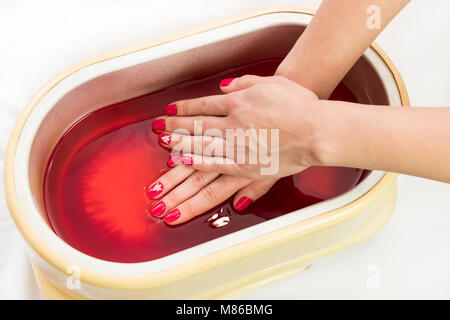 Process paraffin treatment of female hands in beauty salon . Stock Photo