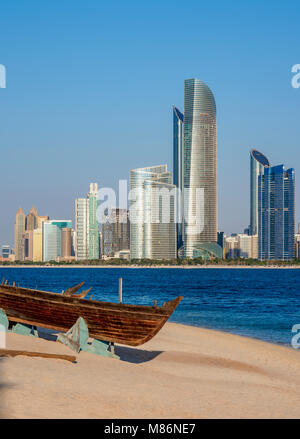 Traditional boat in the Heritage Village with city skyline in the background, Abu Dhabi, United Arab Emirates Stock Photo