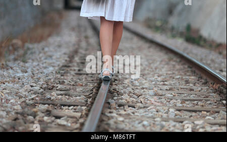 Woman walking along railway tracks Stock Photo