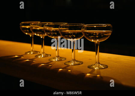 Close-up of a Row of five champagne coupe glasses on a table Stock Photo