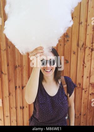 Portrait of a smiling woman holding cotton candy Stock Photo