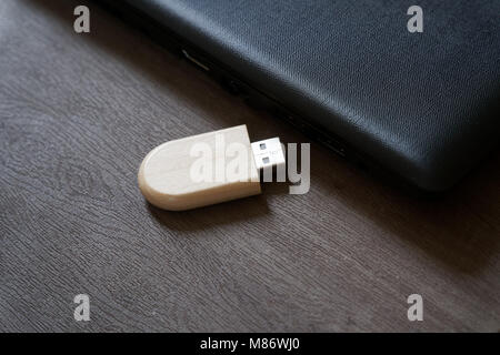 Usb flash drive with wooden surface on desk for USB port plug-in computer laptop for transfer data and backup business concept.