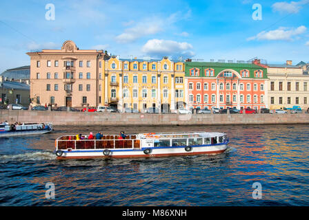 SAINT - PETERSBURG, RUSSIA - MAY 11, 2017:Excursion boats with tourists sail along colorful residential houses on the embankment of The Fontanka River Stock Photo