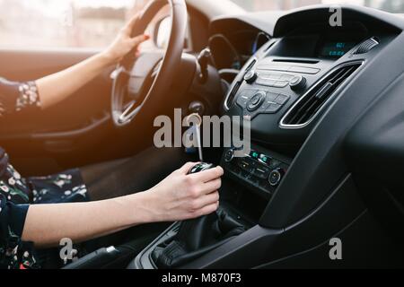 Young woman changing gears in car. Driving a car. Manual transmission. Modern car interior Stock Photo