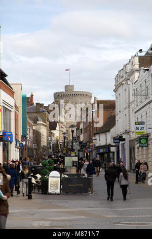 People on Peascod Street in Windsor, England. Windsor Castle, a royal residence, can be seen from the street. Stock Photo
