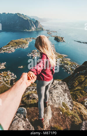 Couple follow holding hands traveling lifestyle on cliff mountain summer vacations outdoor in Norway