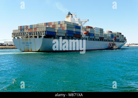 Container ship OOCL OAKLAND (Panama) with tug boat alongside  entering Fremantla harbour, Fremantle, Western Australia Stock Photo