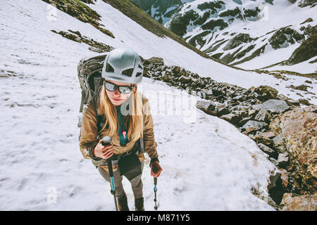 Climber woman hiking in mountains with backpack and helmet gear Traveling lifestyle adventure concept active extreme vacations outdoor Stock Photo